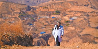 張尚保走在去鐵頭村張家灣自然村出診的路上。