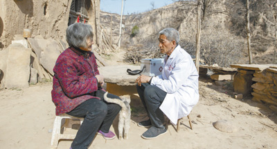 張尚保(右)正在為村民講解健康知識。