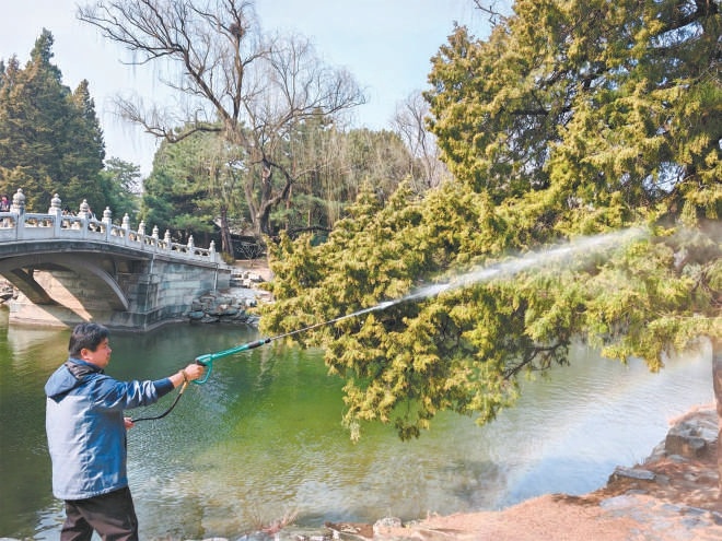 圖為工作人員用高壓水槍進(jìn)行濕化作業(yè)。
