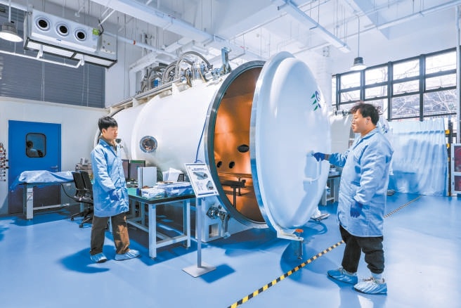 在金隅智造工場商業(yè)航天企業(yè)易動宇航生產(chǎn)車間，研發(fā)人員在真空模擬艙前進行點火測試。