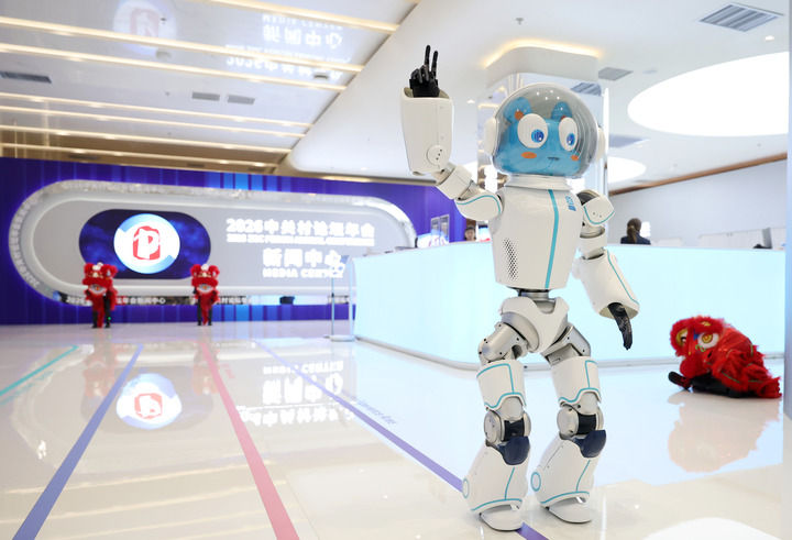 3月24日，在中關(guān)村論壇年會新聞中心內(nèi)，一臺機器人在向觀眾招手。