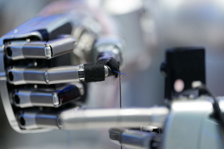 3月24日，在中關(guān)村展示中心常設(shè)展內(nèi)，一臺配備了靈巧手的機器人在展示穿針引線。