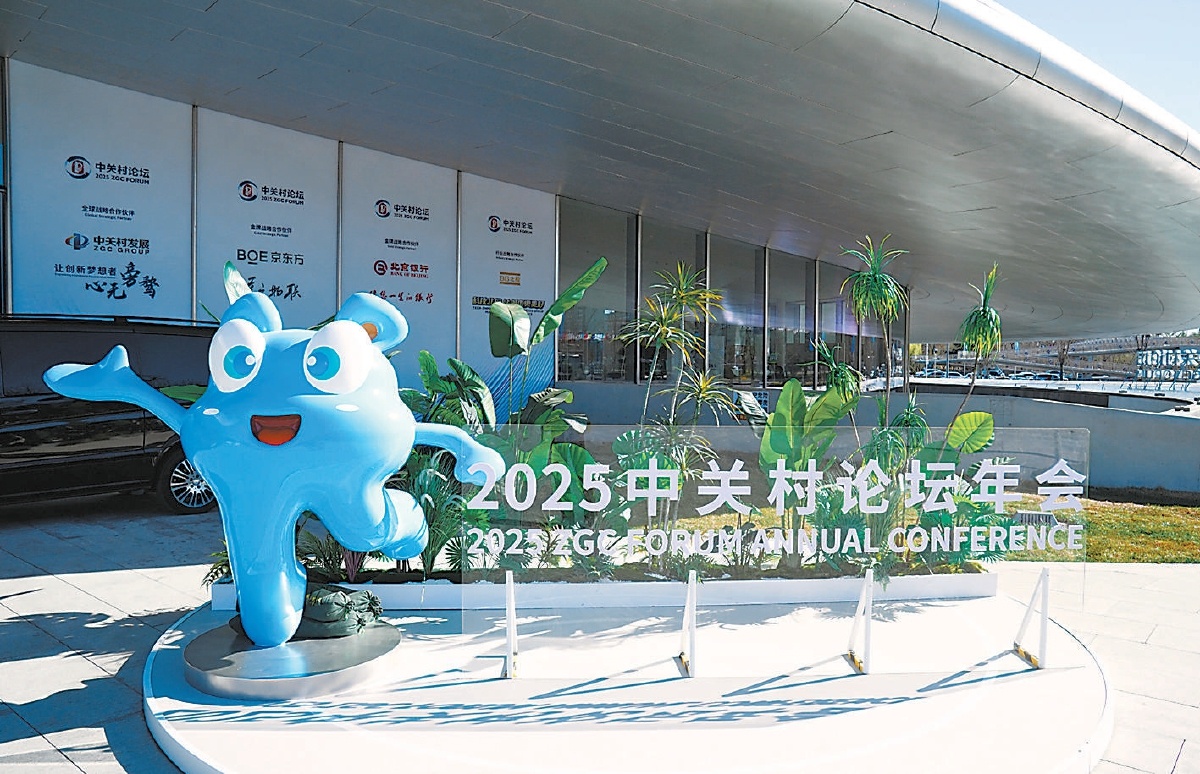 3月26日，2025中關(guān)村論壇年會準備就緒。吉祥物“小關(guān)”在主會場門前歡迎與會嘉賓。