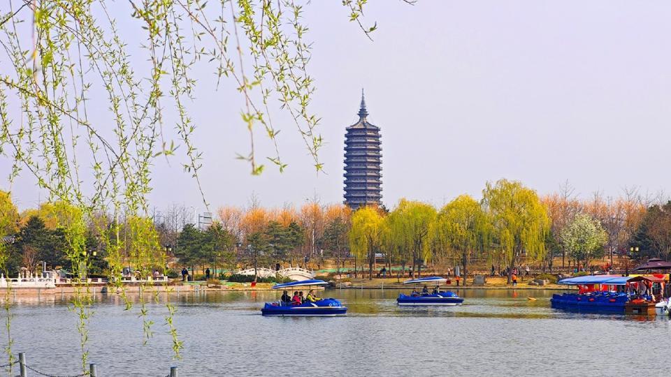 游人泛舟湖上，悠然自得。