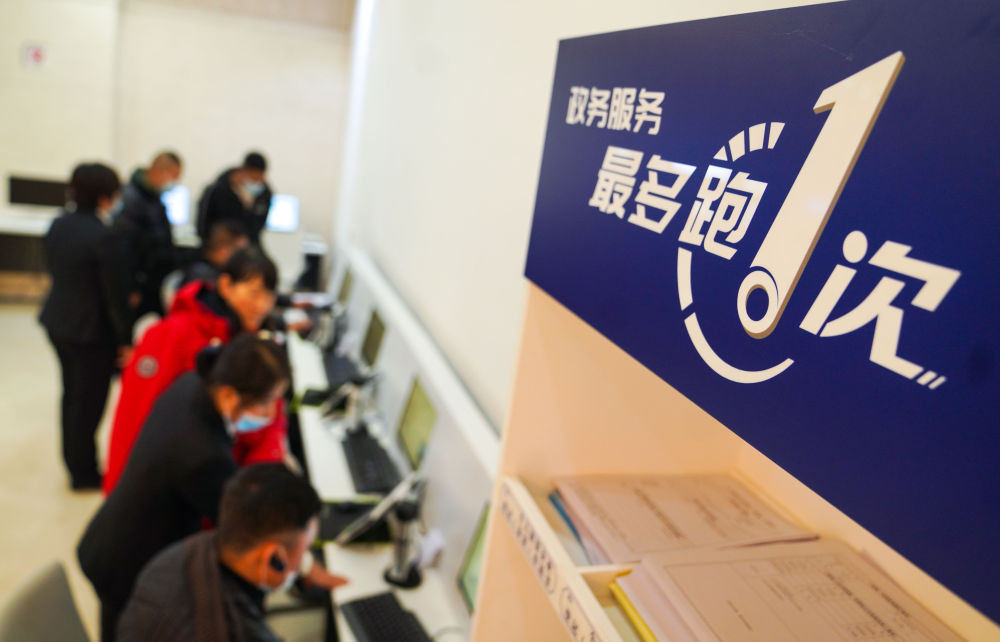在吉林省長(zhǎng)春市二道區(qū)政務(wù)服務(wù)中心輔助填報(bào)區(qū)，市民在工作人員的輔助下進(jìn)行事項(xiàng)填報(bào)（2020年11月23日攝）。