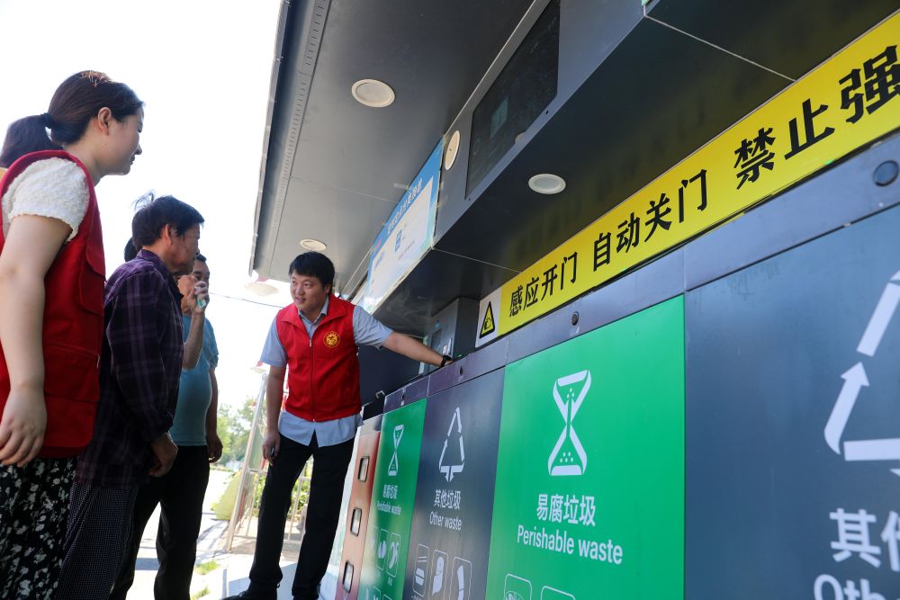 在安徽省合肥市長(zhǎng)豐縣莊墓鎮(zhèn)棗林社區(qū)，志愿者指導(dǎo)居民使用智能垃圾分類回收設(shè)備（2023年9月1日攝）。