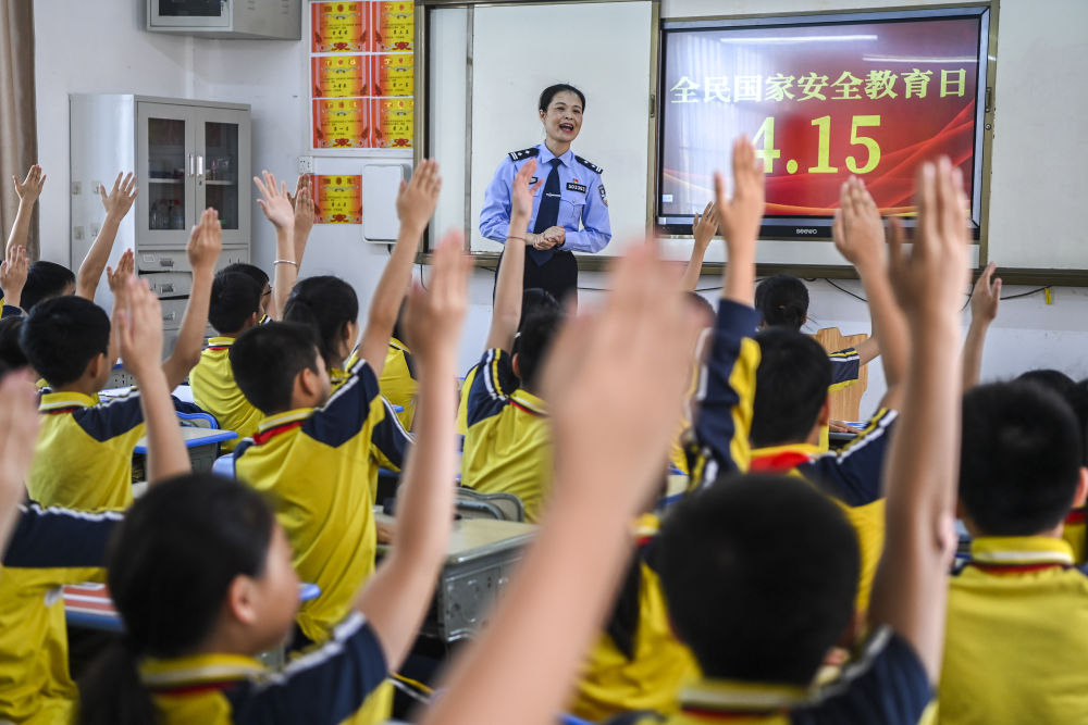 2024年4月15日，在廣西興業(yè)縣一所小學(xué)內(nèi)，公安民警在講解國家安全相關(guān)知識(shí)的過程中與學(xué)生們互動(dòng)。