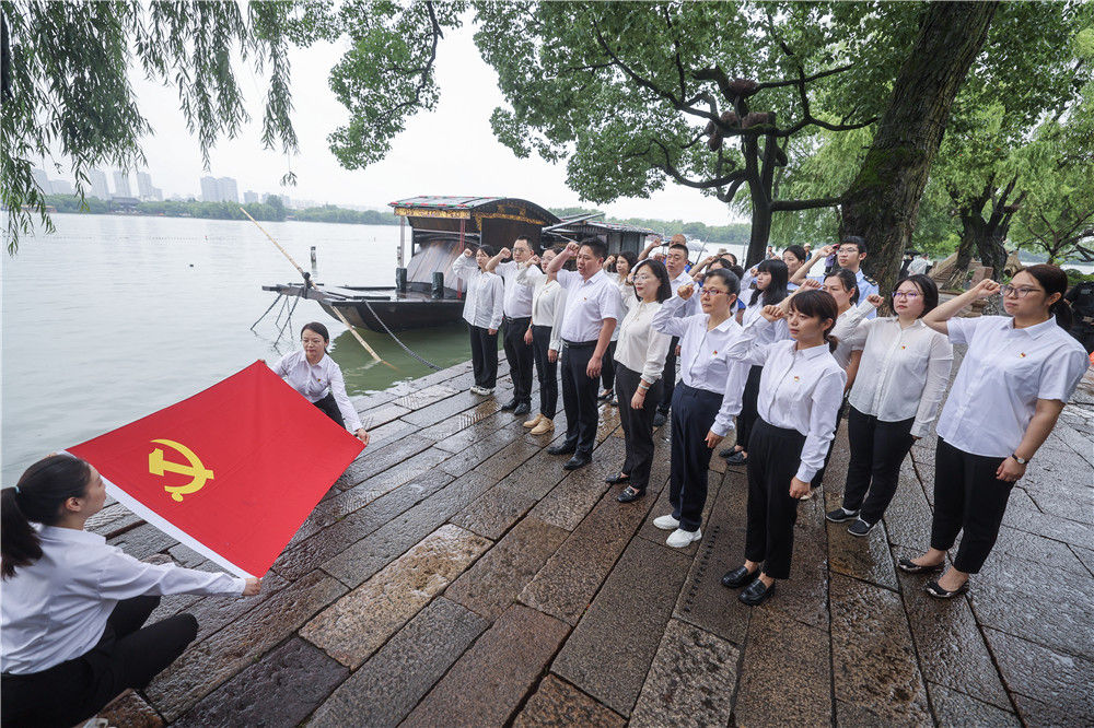 2024年6月28日，黨員們?cè)谡憬闻d南湖紅船旁重溫入黨誓詞。