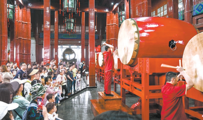 游客在鐘鼓樓景區(qū)欣賞傳統(tǒng)擊鼓表演。