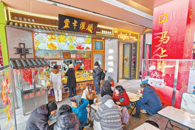 2月12日，在隆福寺豐年灌腸店鋪，市民游客品嘗北京特色小吃。