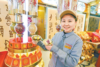 北京稻香村零號(hào)尋寶館店長(zhǎng)曹思源展示特色糕點(diǎn)盤紐糕和琵琶糕。