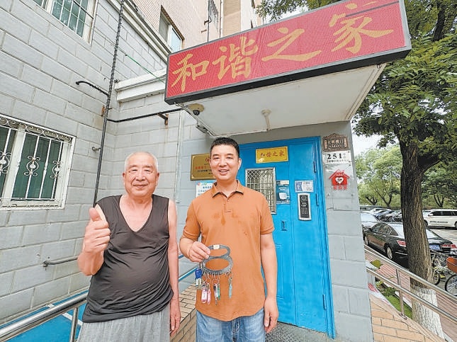 周治國（右）幫鄰居保管鑰匙。