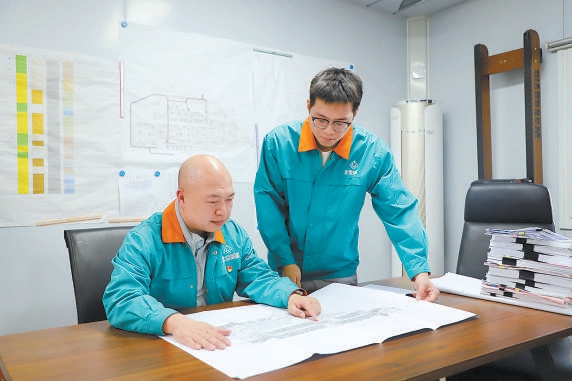 廖陳斌（左）和王思聰一起看項(xiàng)目圖紙。